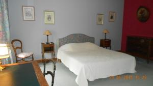 a bedroom with a bed and two chairs and a table at château de lamberville in Lamberville