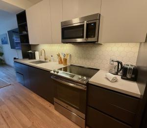 una cocina con fregadero y estufa horno superior en Hollywood Walk of Fame I Pool View I Fitness Center I Free Parking!, en Los Ángeles