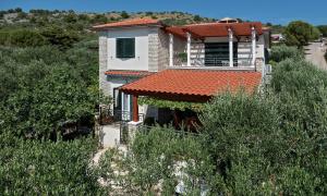 a house with an orange roof on a hill at Apartman Roza in Rogoznica
