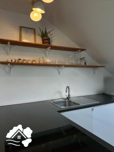 Una encimera de cocina con un fregadero y una pegatina de una casa. en Dreiländer Blick Apartments, en Lörrach