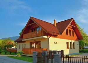 una casa con techo marrón y valla en Apartmany Broma, en Liptovský Mikuláš