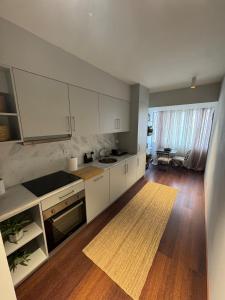 een keuken met witte kasten en een houten vloer bij Casa da Música Apartment in Porto +2 foto's