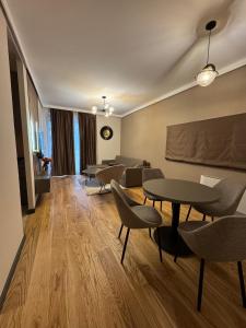 a living room with tables and chairs and a couch at Dukk in Belgrade
