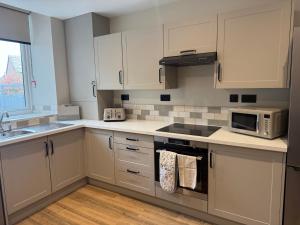 a kitchen with white cabinets and a microwave at 128-130 Crookes in Walkley +5 photos