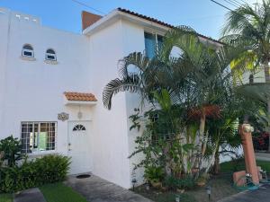 a white house with a palm tree in front of it at Casa Condo Diamante, Nueva Vallarta in Nuevo Vallarta 
