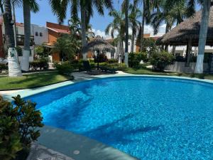 a large blue swimming pool with palm trees at Casa Condo Diamante, Nueva Vallarta in Nuevo Vallarta