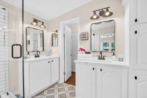 a white bathroom with two sinks and two mirrors at Walk to Blue Jays, Breweries, Marina & Beaches in Dunedin +49 photos