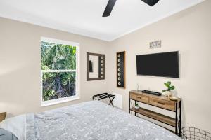 a bedroom with a bed and a television on the wall at Walk to Blue Jays, Breweries, Marina & Beaches in Dunedin