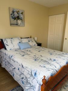 a bedroom with a bed with a blue and white comforter at The Corner Cottage in Palm Harbor