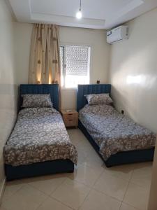 a bedroom with two beds and a window at Spacious Apartment Casablanca in Casablanca