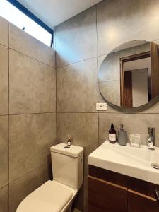 a bathroom with a toilet and a sink and a mirror at SUITE DE LUJO 602 Faro con Aire Acondicionado y Coworking in Medellín +19 photos