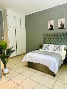 ein Schlafzimmer mit einem großen Bett und einer grünen Wand in der Unterkunft SerenityStay 37 on Zebra in Polokwane
