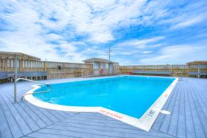 a large swimming pool on a wooden deck with a blue at 7074 - Seashells and Sunsets in Nags Head