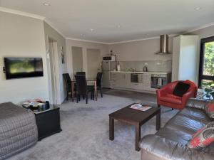 a living room with a couch and a table at Rosandra Retreat in New Plymouth