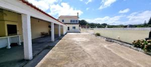 an empty courtyard of a house with a building at The Frenchie's House in Rabo de Peixe