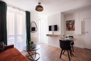 a living room with a couch and a table at Studio rénové - Accès direct Paris in Montreuil