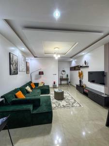 a living room with a green couch and a tv at Oasis Dakar in Dakar