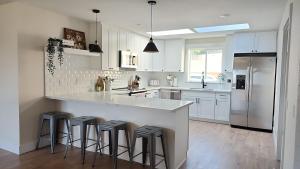 a white kitchen with a large island with bar stools at Sandy Pacific Hideaway 1 in Florence