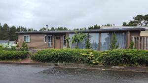 a small house with bushes in front of it at Sandy Pacific Hideaway 1 in Florence