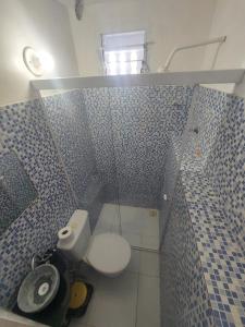 a bathroom with a toilet and a blue tiled wall at Pousada Casa Sonhos in São Luís