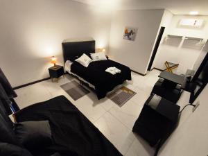 a bedroom with a black bed and a couch at Hotel Pousada Estalagem Floradas da Serra in São Joaquim +39 photos
