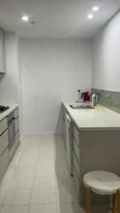 una cucina bianca con un lavello e un bancone di One bedroom with Spacious n Amazing water view apartment a Melbourne Altre 17 foto