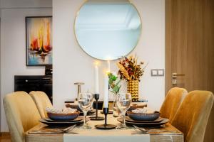 a dining room table with a round mirror on the wall at chic & cozy Apartment, Parc Serenity in Mohammedia