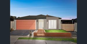 a house with a orange door and a yard at Tarneit Treasure in Tarneit