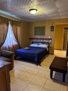 Alto BoqueteにあるLegado Residenceのベッドルーム(青いベッド1台、ソファ付)