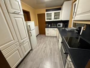a kitchen with white cabinets and a wooden floor at Sleep Point Bremermann in Bremen