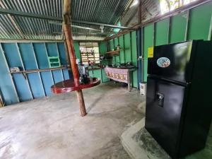 a room with a refrigerator and a table in it at Marea Viajera - Hostal in Drake Bay Airport