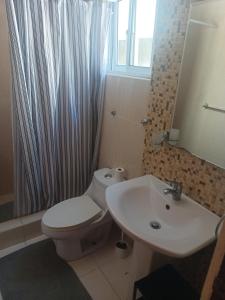 a bathroom with a white toilet and a sink at Martina II Stay in Santo Domingo +5 photos