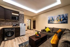 a living room with a couch and a kitchen at فندق فيو الشاطي - Beach View Hotel in Dammam
