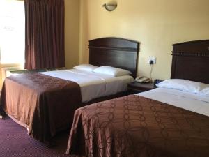 a hotel room with two beds and a phone at Carlton Motor Lodge in Los Angeles