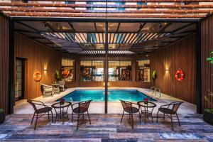 a pool with tables and chairs next to a pool at Beach View Hotel in Dammam