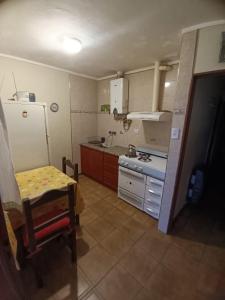 a small kitchen with a table and a refrigerator at PUNTA ALTA Encanto in Punta Alta