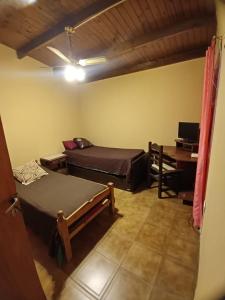 a room with two beds and a desk in it at PUNTA ALTA Encanto in Punta Alta