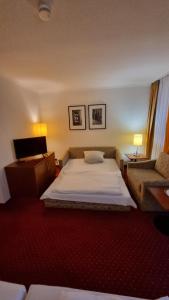 a hotel room with a bed and a couch at A&S City Hotel am Rosenpark in Aachen