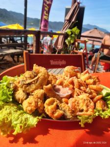 a plate of shrimp and lettuce on a table at Pousada Traineira in Trindade +69 photos