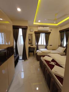a hotel room with two beds and a television at Hotel Legacy Grand - Rooms & Suites - Near AIG Hospital in Hyderabad