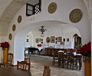 a dining room with a table and a grand piano at Masseria Vagone in Macchia di Monte