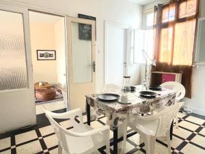 a dining room with a table and white chairs at Appartement Spacieux pour Famille Mâarif Casablanca in Maarif