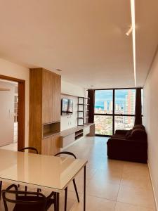 a kitchen and living room with a table and chairs at Apartamento Aconchegante e Moderno com Vista Espetacular da Cidade! in Campina Grande
