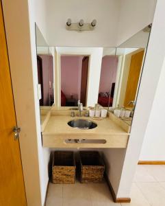a bathroom with a sink and a mirror at Dpto céntrico VGB in Villa General Belgrano