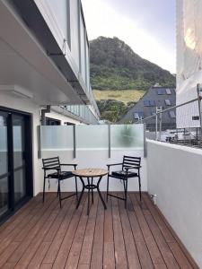 a patio with three chairs and a table on a balcony at Beach escape at Mount Maunganui in Mount Maunganui