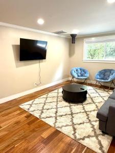 a living room with a couch and a tv at The Mossy Nook A Cozy Escape in the Woods! in Issaquah +33 photos
