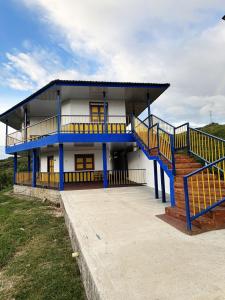 a blue and white house with a staircase in front of it at Casa Quindiana in Zarzal