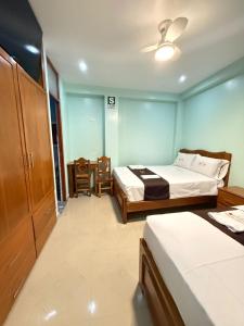 a hotel room with two beds and a table and chairs at Hostal Corazon A Corazon in Chiclayo