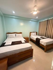 two beds in a room with blue walls at Hostal Corazon A Corazon in Chiclayo