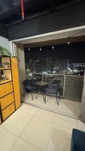 a balcony with a table and chairs and a view of a city at Apartamento moderno e completo no shopping DF Plaza in Brasilia +4 photos